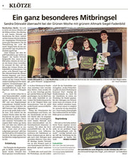 Sandra Dörwald präsentiert auf der Grünen Woche in Berlin ein Fadenbild mit dem Regionalsiegel „echt Altmark“.