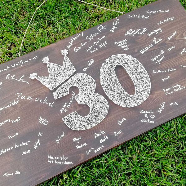 Fadenbild Gästebuch mit Zahl und Unterschriften auf Holzbrett